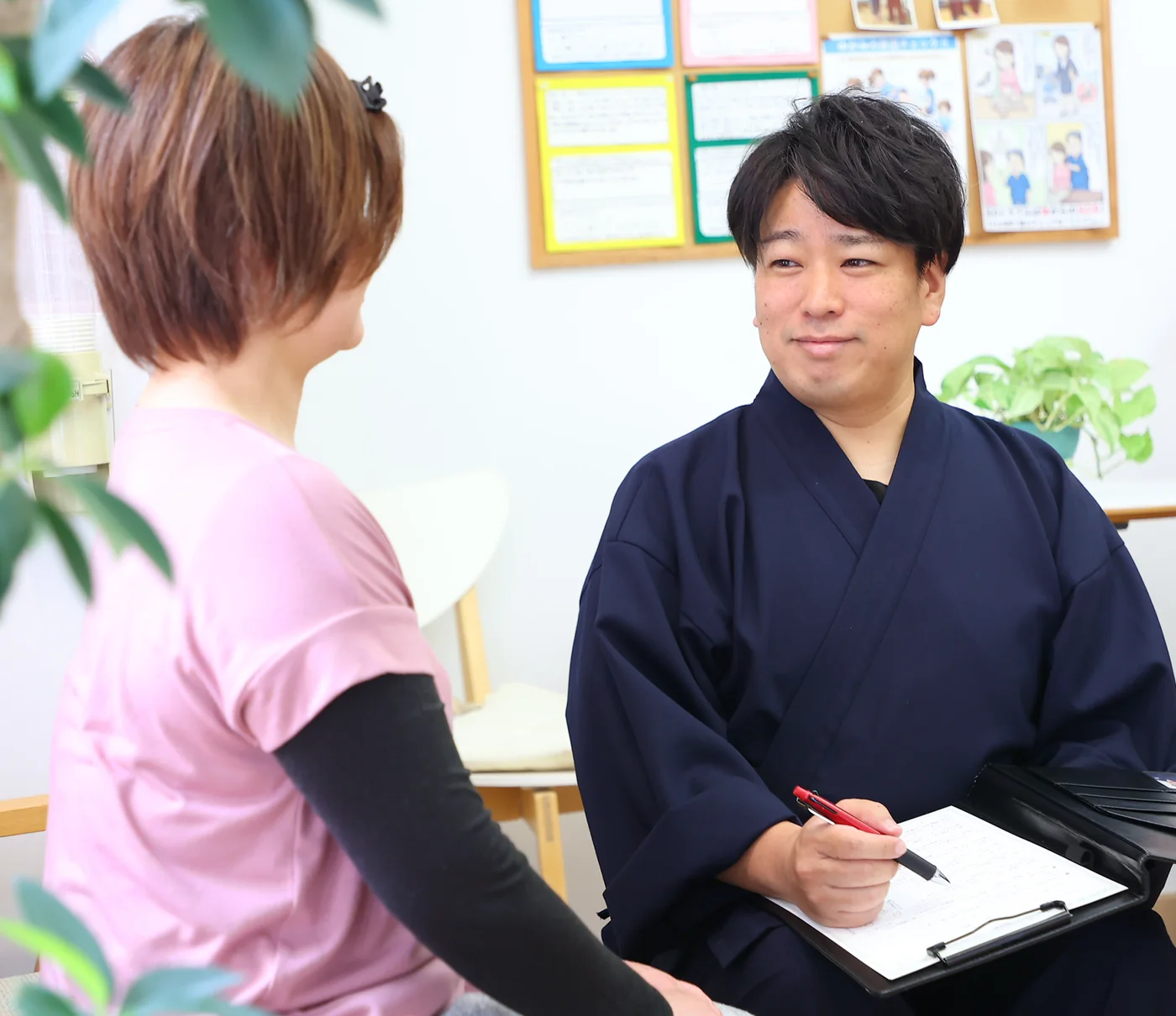 腰ひざ専門よしかわ整体院で院長が骨模型を使って説明している様子